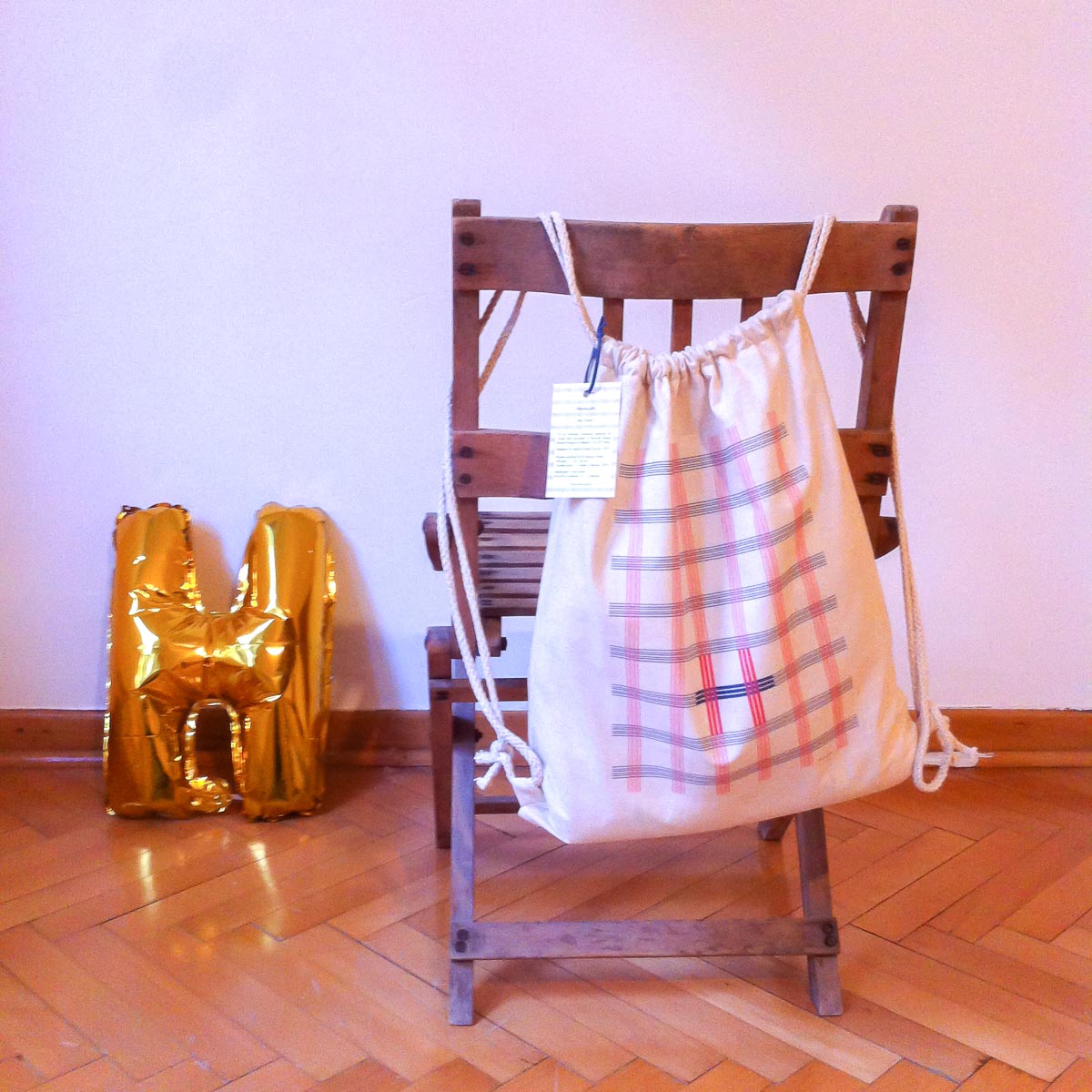 Collections-H-Bag-Ekose-Hanging-Hamide-Design-Studio "Ekose" backpack hanging on the back of a chair
