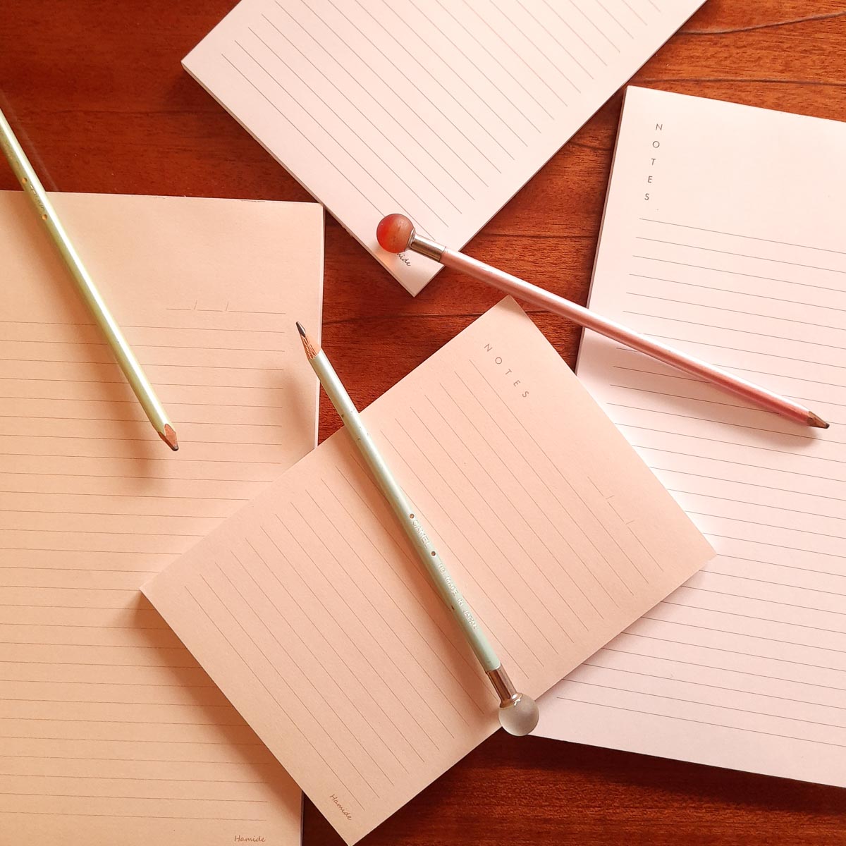 Collections-Basics-Notepads-Editorial-Light-Peach-White-Grey-Hamide-Design-Studio Hamide Basics notepads laying on a table with pencils