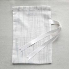 Front of medium reusable tulle sac in white with blue stripes for shopping groceries
