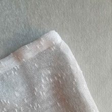 Texture of large reusable tulle sac in gradient green for shopping groceries