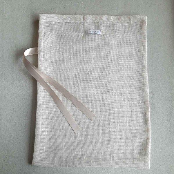 Back of large reusable tulle sac in cream for shopping groceries