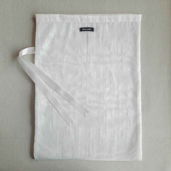 Back of large reusable tulle sac in white for shopping groceries